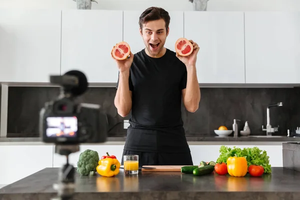 Jovem animado filmando seu vídeo blog episódio — Fotografia de Stock