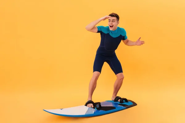 Immagine di Surprised happy surfer in muta con tavola da surf — Foto Stock