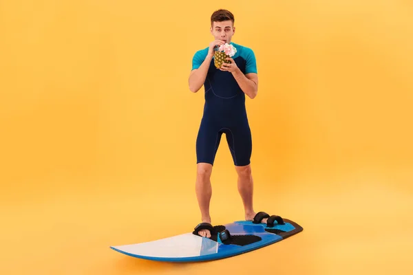 Bild eines lächelnden Surfers im Neoprenanzug mit Surfbrett — Stockfoto
