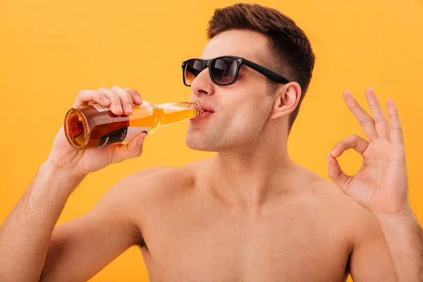 Close-up view of Smiling naked man in sunglasses drinking beer — Stock Photo, Image