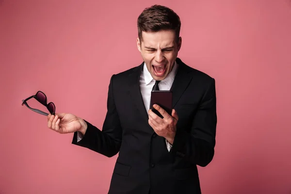 Angry screaming displeased young businessman talking by phone — Stock Photo, Image