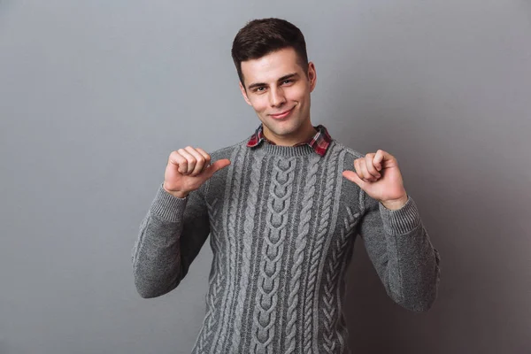 Усміхнений брюнетка людина в светрі вказує на себе — стокове фото