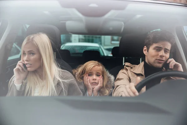 Sad little girl sitting in car while her parents talking — Stock Photo, Image