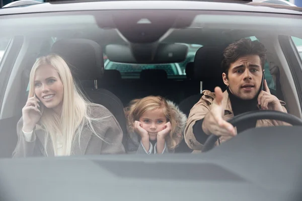 Niña triste sentada en el coche mientras sus padres hablan — Foto de Stock