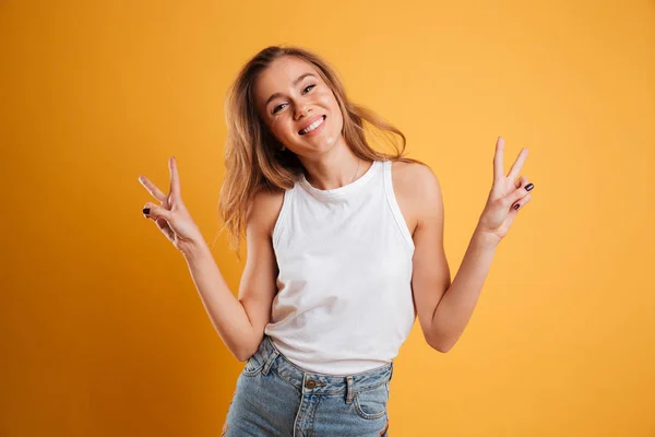 Portrét šťastná mladá dívka ukazuje mírové gesto — Stock fotografie