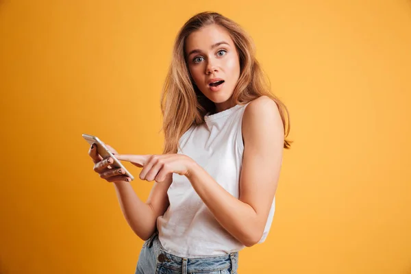 Portrét zmatená mladá dívka drží mobilní telefon — Stock fotografie