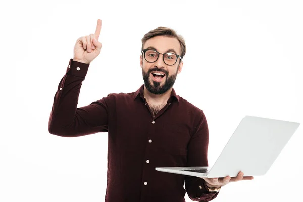 Portréja egy izgatott szakállas ember tartja a laptop számítógép — Stock Fotó