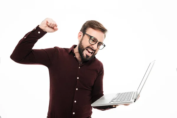 Retrato de un hombre barbudo feliz sosteniendo ordenador portátil —  Fotos de Stock