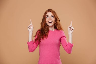 İşaret eden bir neşeli genç Kızıl saçlı kız portresi