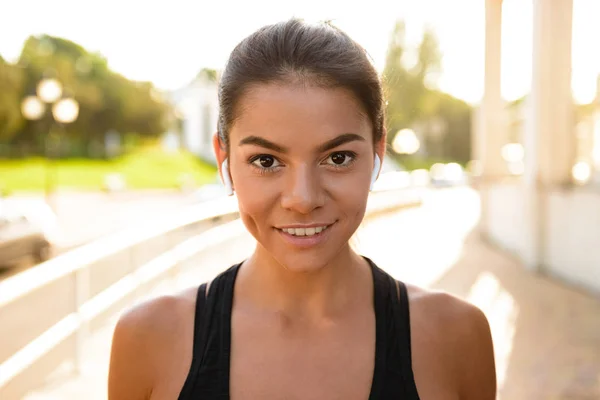 Närbild porträtt av en ung fitness kvinna i hörlurar — Stockfoto