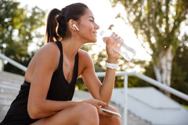 Kulaklık gülümseyen bir fitness kız portresi