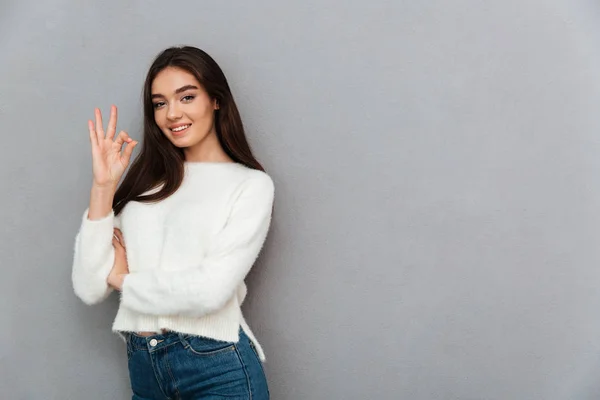 Linda joven morena en suéter blanco esponjoso mostrando OK ges —  Fotos de Stock