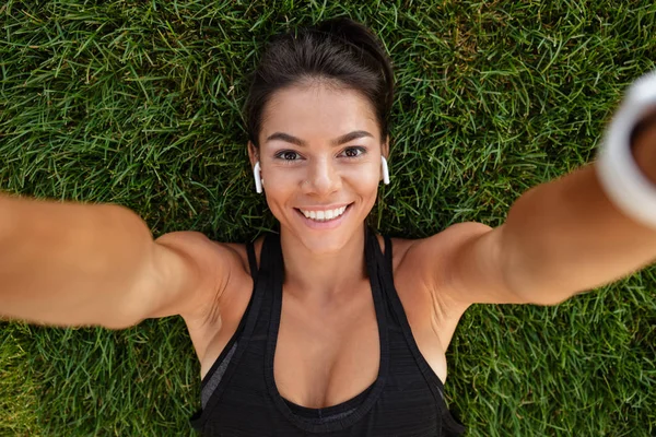 Närbild av en happy fitness flicka i hörlurar — Stockfoto