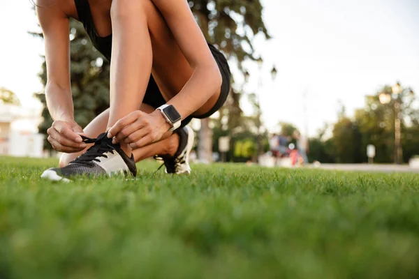 Primer plano de chica fitness atándose los cordones —  Fotos de Stock