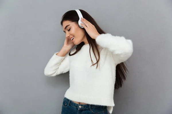 Felice donna bruna in maglione e cuffie ascoltare musica — Foto Stock