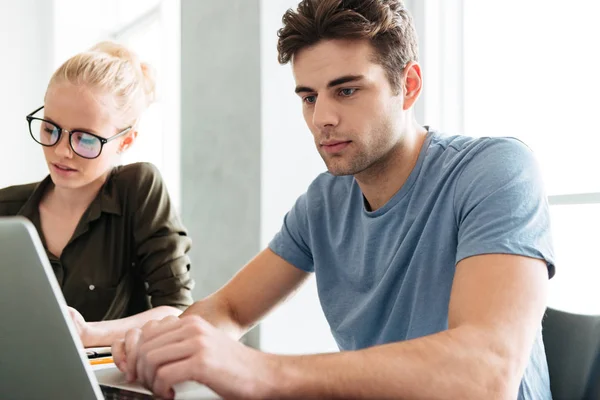 Young busy couple working at home