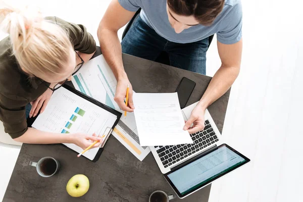 Bovenaanzicht van het jonge paar werk met papieren en laptop thuis — Stockfoto