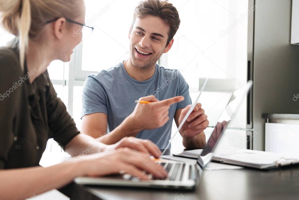 Cheerful man work with her man at home with laptop