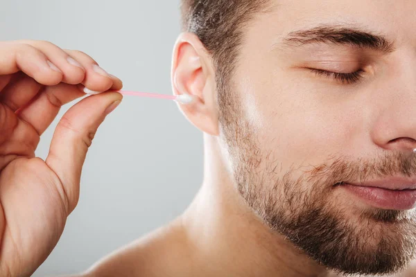 Ritratto ravvicinato di un giovane uomo che si pulisce le orecchie — Foto Stock