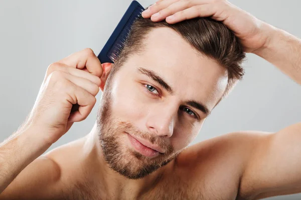 Retrato de cerca de un hombre sonriente peinándose el pelo — Foto de Stock