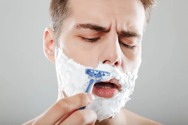 Закрыть портрет концентрированного человека с пеной для бритья — стоковое фото