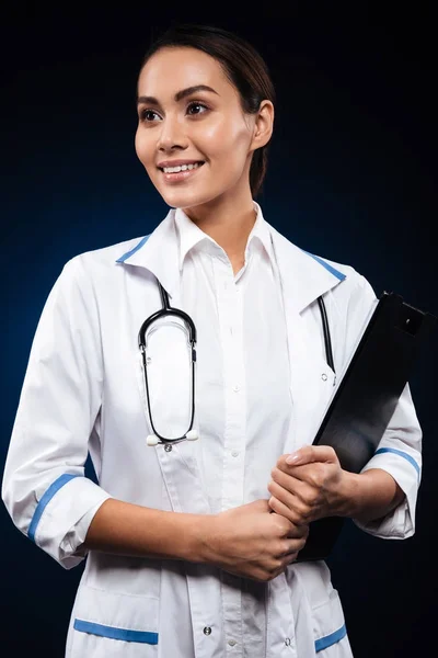 Portrét mladých veselá lékaře drží složku a dívá se stranou — Stock fotografie