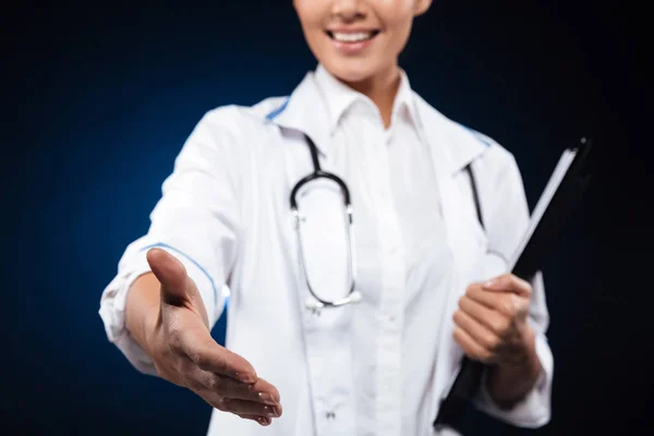 Abgeschnittenes Foto einer fröhlichen Krankenschwester, die Ordner hält und die Hand ausstreckt — Stockfoto