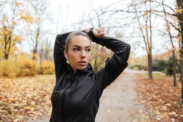Porträtt av en säker fitness flicka i hörlurar — Stockfoto