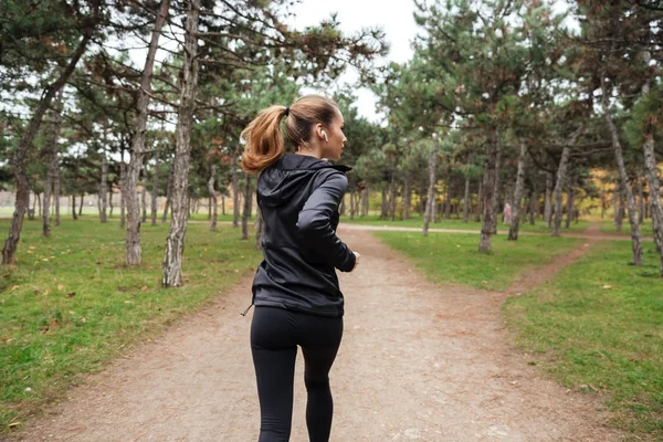 Baksidan på en fitness kvinna jogging — Stockfoto