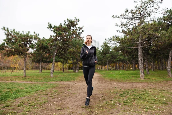 Retrato de una bonita chica de fitness con auriculares funcionando — Foto de Stock