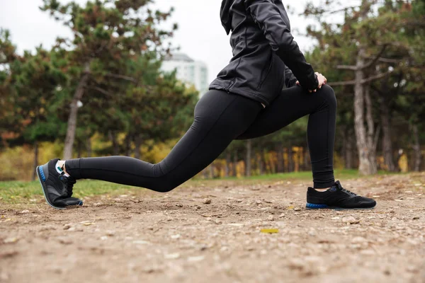 Bijgesneden afbeelding van een meisje van de fitness benen rekken — Stockfoto