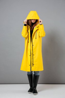 Yağmurluk giymiş genç bir kızın portresi tam uzunlukta