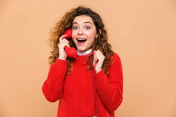 Retrato de uma garota surpresa falando em um telefone fixo — Fotografia de Stock