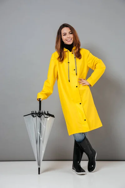 Retrato de comprimento total de uma menina sorridente vestida com capa de chuva — Fotografia de Stock