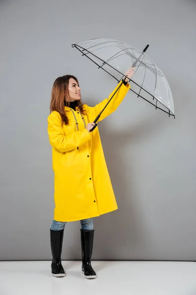 Full length portrait of a smiling girl dressed in raincoat