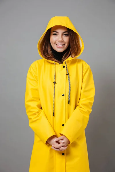 Porträtt av en leende flicka klädd i regnrock poserar — Stockfoto