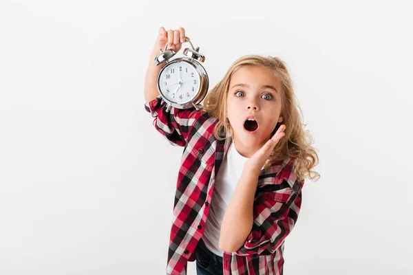 Portrait of a surprised little girl showing alarm clock — Stock Photo, Image