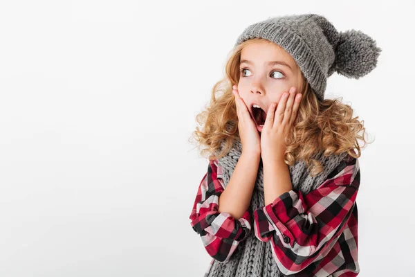 Porträtt av en chockad liten flicka klädd i vintermössa — Stockfoto