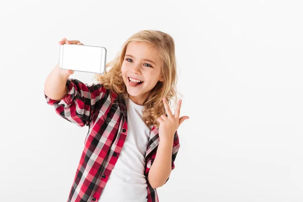 Retrato de una niña alegre tomando una selfie —  Fotos de Stock