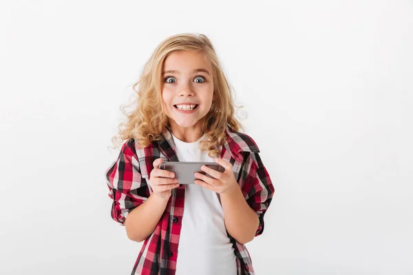 Ritratto di una bambina eccitata che tiene il cellulare — Foto Stock