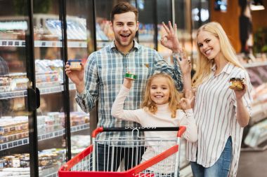 Yiyecek seçme ve ok jest gösterilen gülümseyen aile