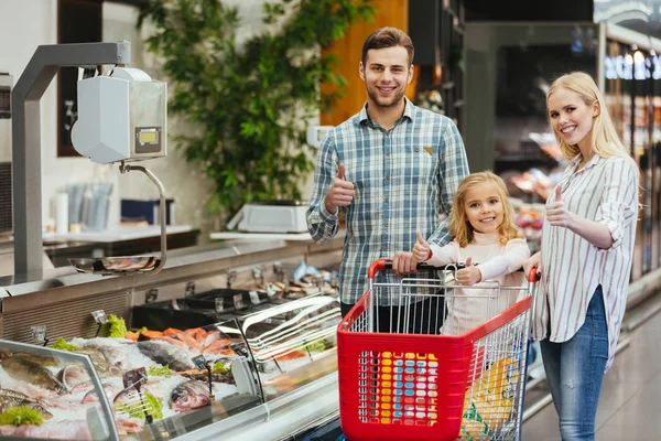 Familia sonriente eligiendo comestibles —  Fotos de Stock