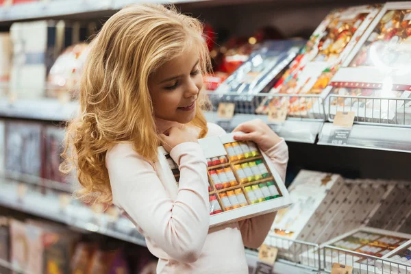 Mosolygós kislány, candy a szupermarketben kiválasztása — Stock Fotó