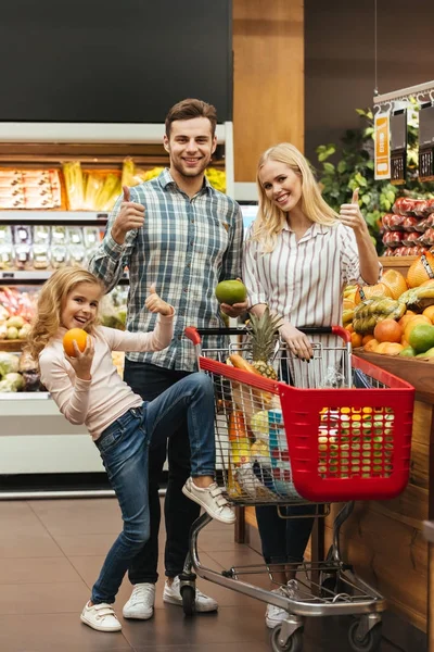 Famiglia sorridente che sceglie generi alimentari — Foto Stock