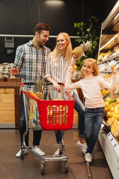 Familia feliz eligiendo alimentos juntos — Foto de Stock