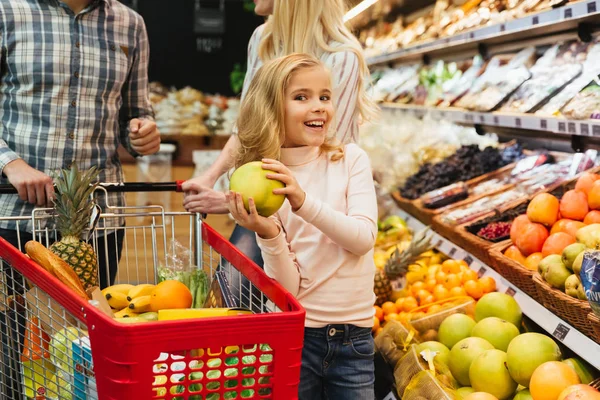 Улыбающаяся маленькая девочка покупает продукты — стоковое фото