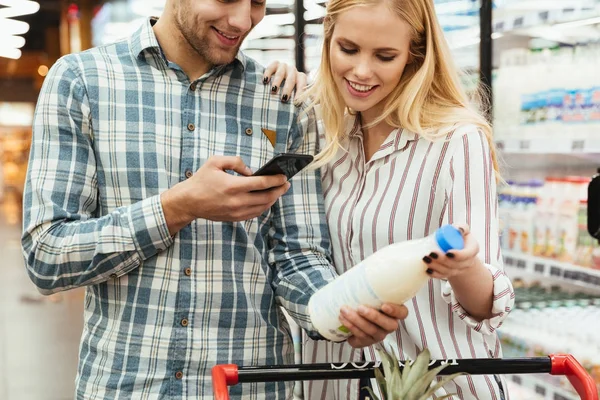 Paar liest Einkaufsliste im Supermarkt — Stockfoto