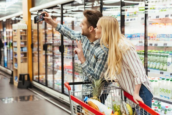 Glückliches junges Paar zeigt Friedensgeste — Stockfoto