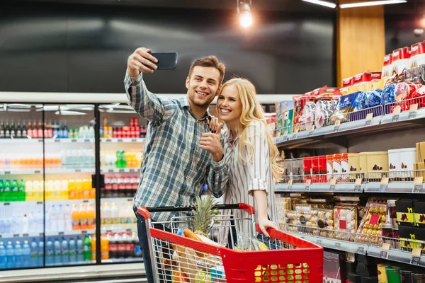 Sonriente pareja mostrando pulgares hacia arriba — Foto de Stock