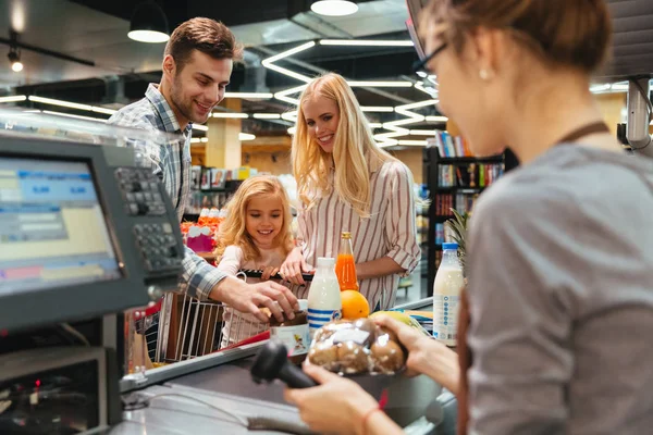 Giovane famiglia in piedi al bancone del contante — Foto Stock